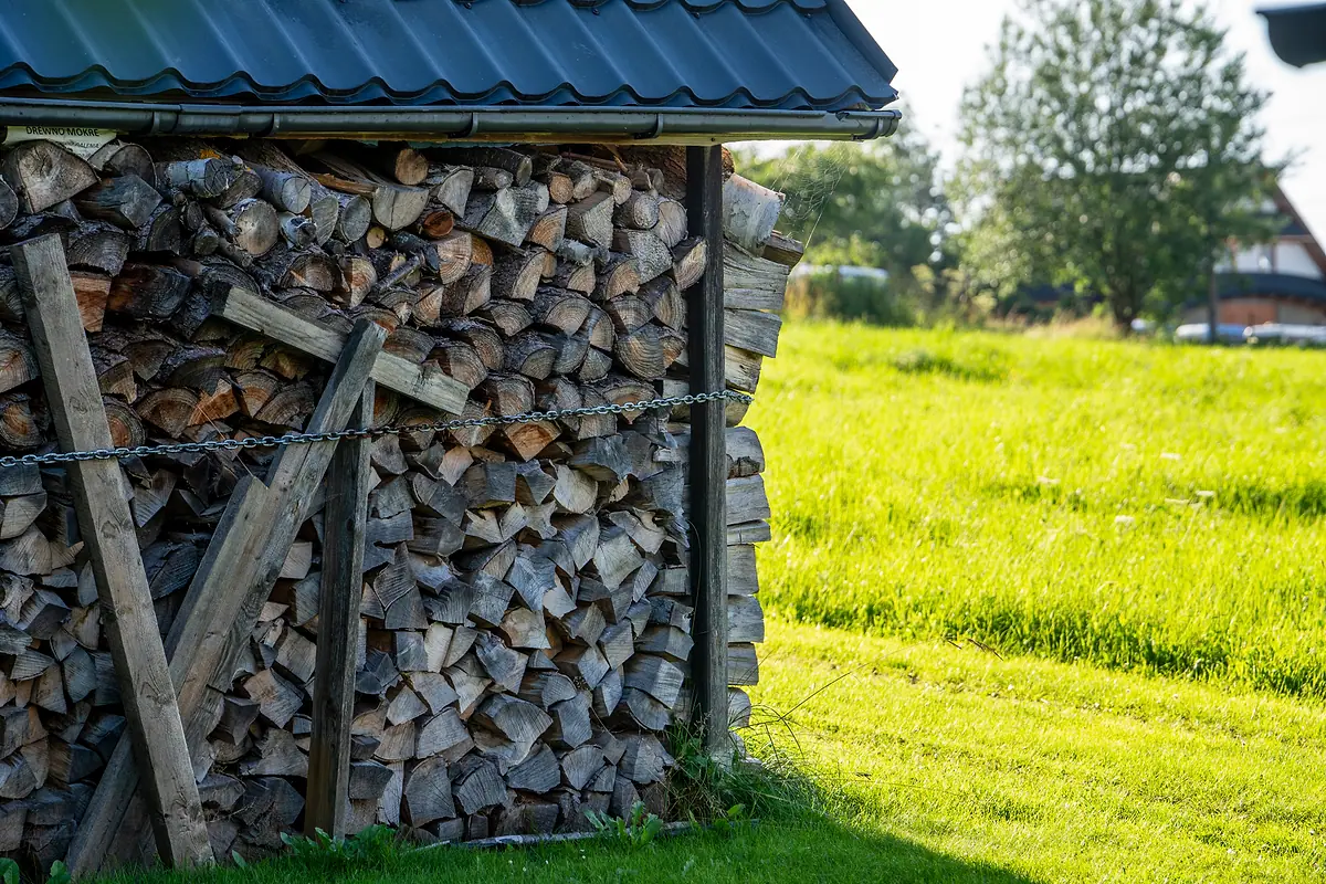 Drewutnia z porąbanym drewnem przy domu