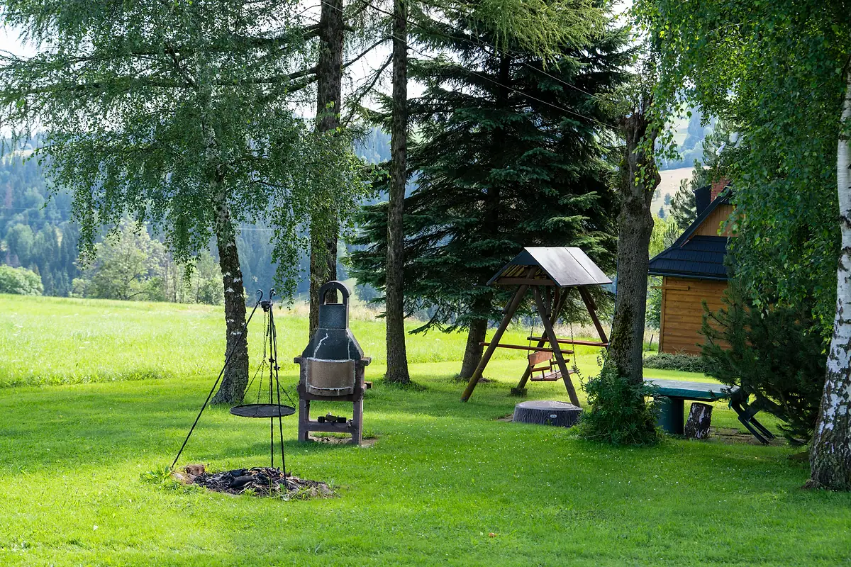Palenisko z kociołkiem, grill i huśtawka w ogrodzie