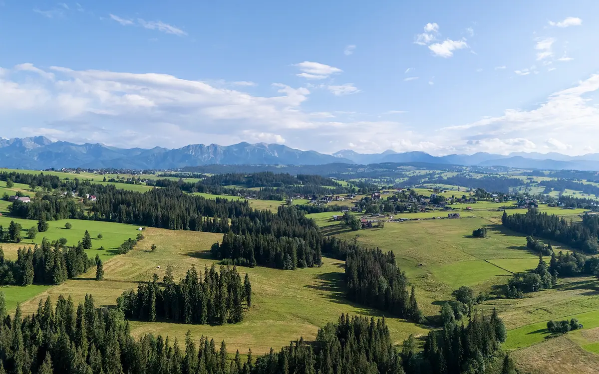 Panorama Tatr nad zielonymi wzgórzami Podhala